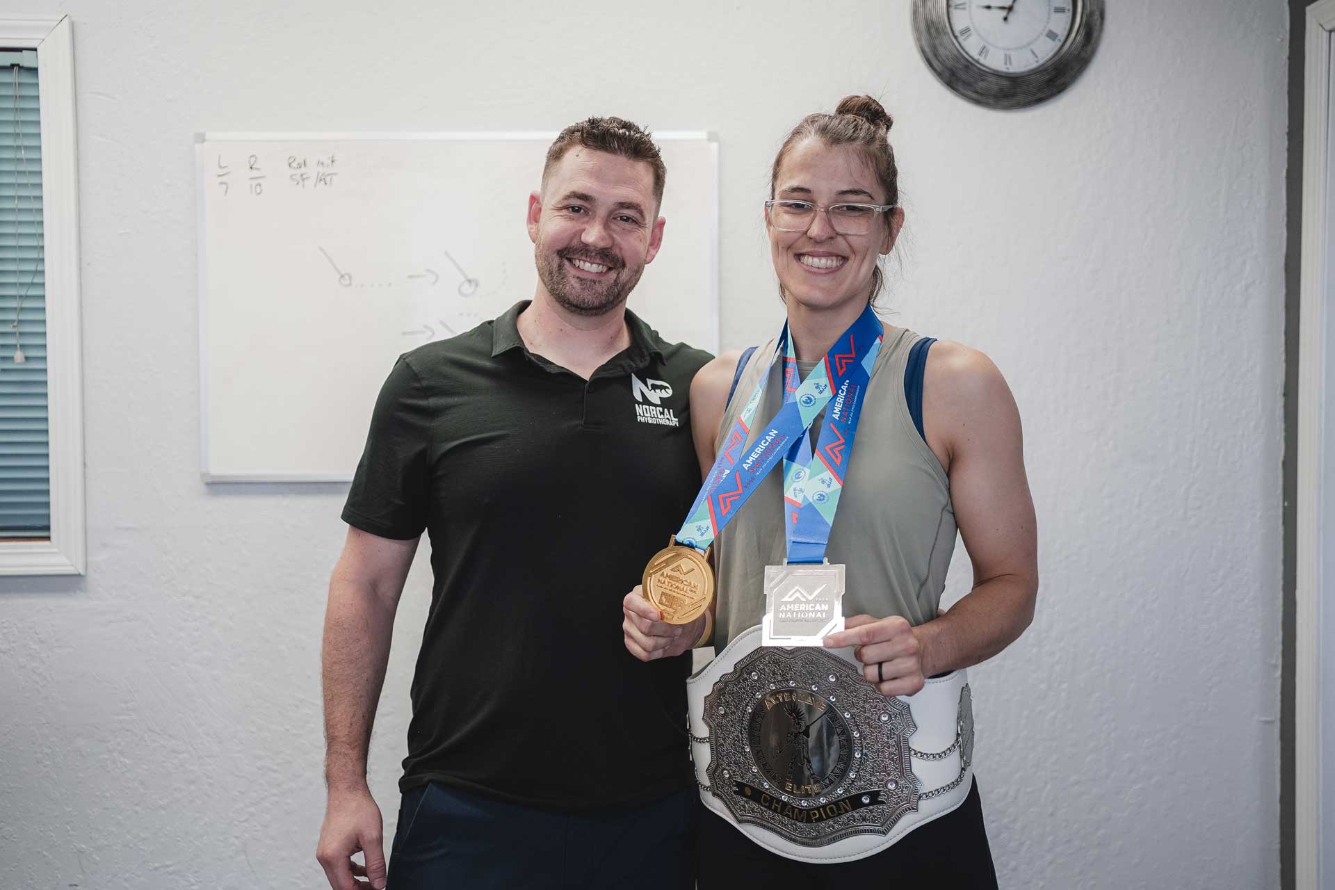 An athlete wearing two medals and a belt medal.