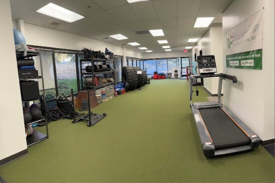 A room full of various excercise equipment, ranging from treadmills to dumbells. Large room